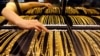 FILE - An employee arranges gold jewelry in a display case as her arm is reflected in the mirror, at a gold shop in Wuhan, Hubei province, Aug. 25, 2011. 