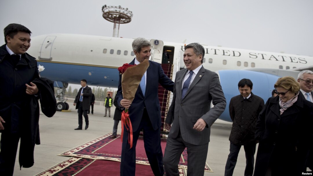 Menlu AS John Kerry (tengah, kiri) disambut oleh Menlu Kyrgizstan Erlan Abdyldaev setibanya di bandara internasional Manas di Bishkek (31/10).