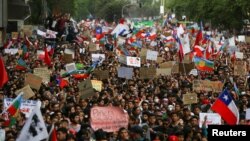 Una democtración de protesta con pancartas y banderas inunda las calles de Santiago de Chile el 25 de octubre de 2019. Reuters.