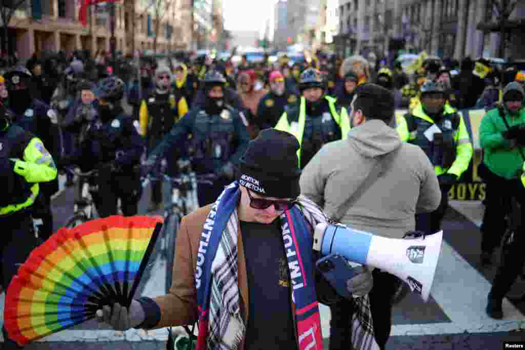 An anti-protester demonstrating against the members of the far-right Proud Boys, in the background, is seen on the inauguration day of Donald Trump's second presidential term in Washington, Jan. 20, 2025. 