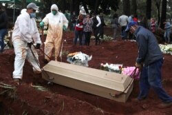 FILE - Relatives react as gravediggers bury the coffin of Eriveltu Aparecido Spada, 57, suspected to have died from the coronavirus disease (COVID-19), at Vila Formosa cemetery, in Sao Paulo, Brazil, June 27, 2020.