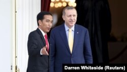 Presiden Indonesia Joko Widodo (kiri) dan Presiden Turki Recep Tayyip Erdogan mengobrol sambil melihat taman dari balkon di istana presiden di Jakarta, 31 Juli 2015. (Foto: REUTERS/Darren Whiteside)