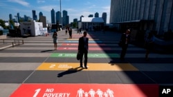 People walk along a plaza at United Nations Headquarters, Sept. 21, 2019.