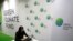 FILE - A woman works her computer at the Green Climate Fund stand at the COP21, United Nations Climate Change Conference, Monday, Nov. 30, 2015 in Le Bourget, north of Paris.