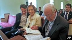 FILE - In this photo taken Sunday, June 8, 2014, Rosalynn and Jimmy Carter during a church service in Plains, Georgia, sitting with their grandson, Jason.