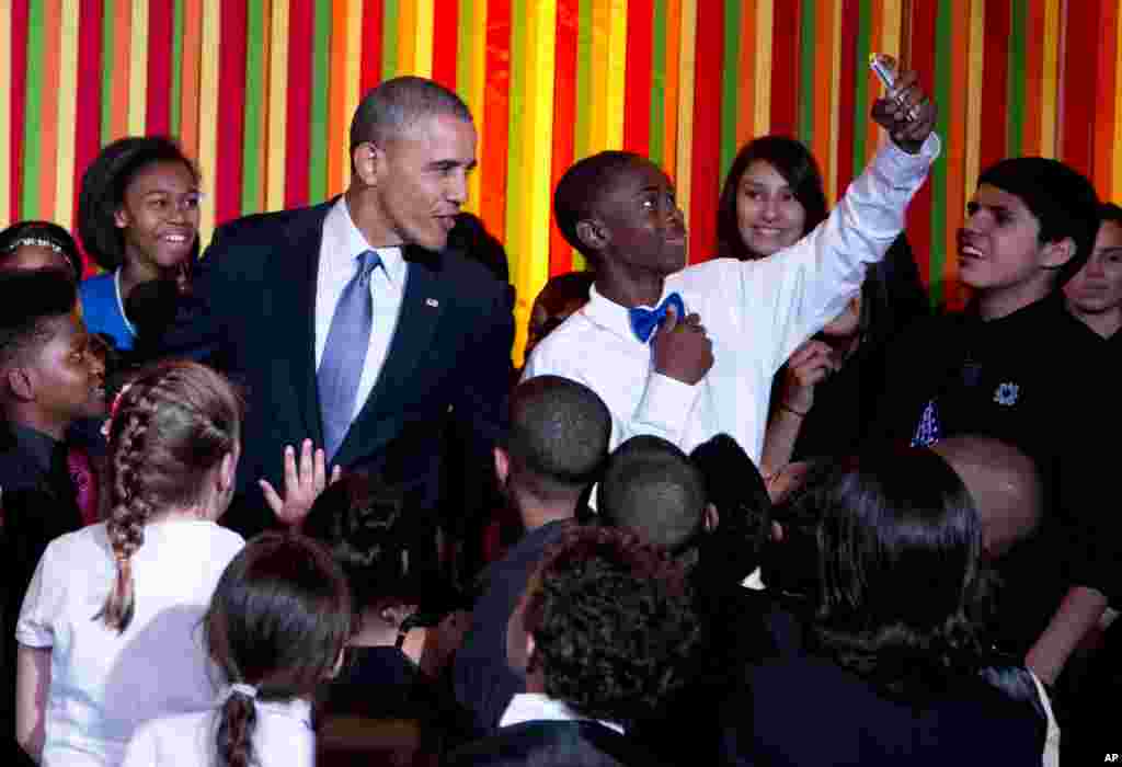 President Barack Obama takes a "selfie" on stage with a a student from the ReNew Cultural Arts Academy, from New Orleans, during the White House Talent Show in the East Room of the White House, Tuesday, May 20, 2014 in Washington. The talent show was host