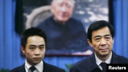 Mantan pemimpin partai komunis Chongqing, Bo Xilai (kanan) dan anaknya Bo Guagua berpose di depan foto ayahnya, politisi partai komunis, Bo Yibo (Foto: dok). Bo Guagua, membantah tuduhan terkait pembiayaan kehidupan mewah dan pendidikannya di luar negeri.