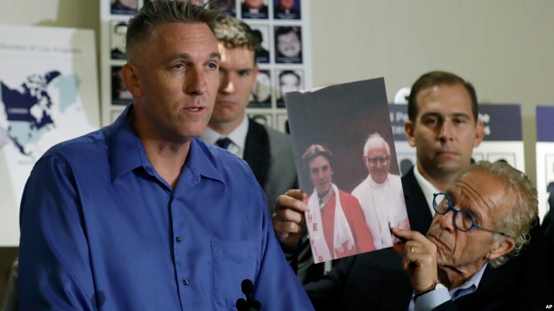 Tom Emens, left, who was sexually abused by a priest, speaks on his experience next to attorney Jeff Anderson, Oct. 2, 2018, in Los Angeles. 