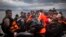 FILE - Refugees and migrants arrive on a beach after crossing a part of the Aegean sea from the Turkey's coast to the Greek island of Lesbos, Nov. 28, 2015.