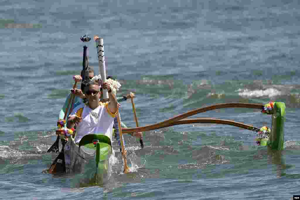 Brazilian canoeist Rubens Pompeu carries the Olympic flame during a tour through Paranoa lake in Brasilia, Brazil.&nbsp;The Olympic flame arrived to Brazil kicking off a three-month torch relay throughout the country that will finish at the Maracana stadium on Aug. 5, 2016, with the opening ceremony of the Rio 2016 Olympic Games.