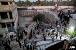 Supporters of Iraqi Shiite cleric Moqtada al-Sadr climb the fence outside the Swedish Embassy in Baghdad on July 20, 2023, during a protest against a planned action to burn the Quran in Stockholm, Sweden. (Ahmad AL-Rubaye /AFP)