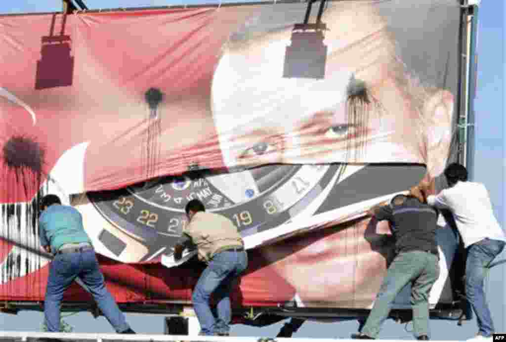 Lebanese men of Armenian descent, tear up a poster showing Turkish Prime Minister Recep Tayyip Erdogan as they protest against his visit, in Beirut's Martyrs' Square, Lebanon, Thursday, Nov. 25, 2010. (AP Photo/Assad Ahmad)