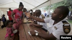 Refugees fleeing anti-immigrant violence are processed by immigration officers at a transit camp in Beitbridge, ZImbabwe, April 24, 2015.