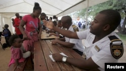 Refugees fleeing anti-immigrant violence are processed by immigration officers at a transit camp in Beit Bridge, ZImbabwe, April 24, 2015.