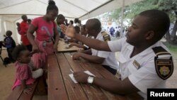 Refugees fleeing anti-immigrant violence are processed by immigration officers at a transit camp in Beit Bridge, ZImbabwe, April 24, 2015.