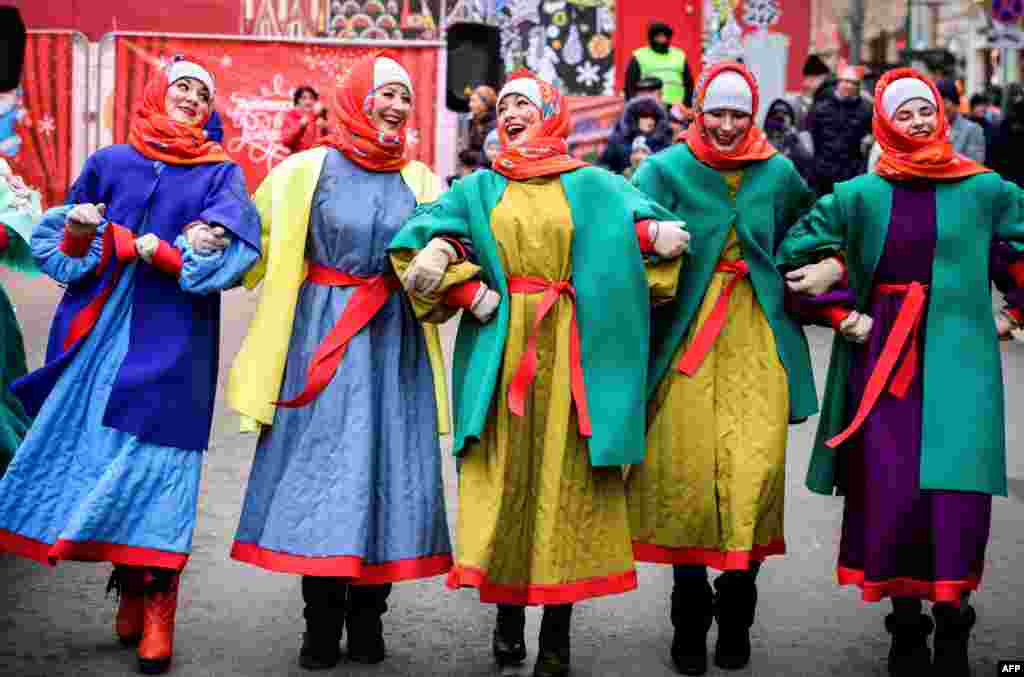 Street performers dance on Tverskaya Street during a festival marking the New Year and Christmas in central Moscow, Russia.