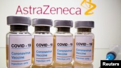 Vials with a sticker reading, "COVID-19 / Coronavirus vaccine / Injection only" and a medical syringe are seen in front of a displayed AstraZeneca logo in this illustration taken October 31, 2020. REUTERS/Dado Ruvic/Illustration/File Photo