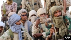 FILE - Tuaregs fighters of the Coordination of Movements of the Azawad (CMA) sit as they gather near Kidal, northern Mali on September 28, 2016.