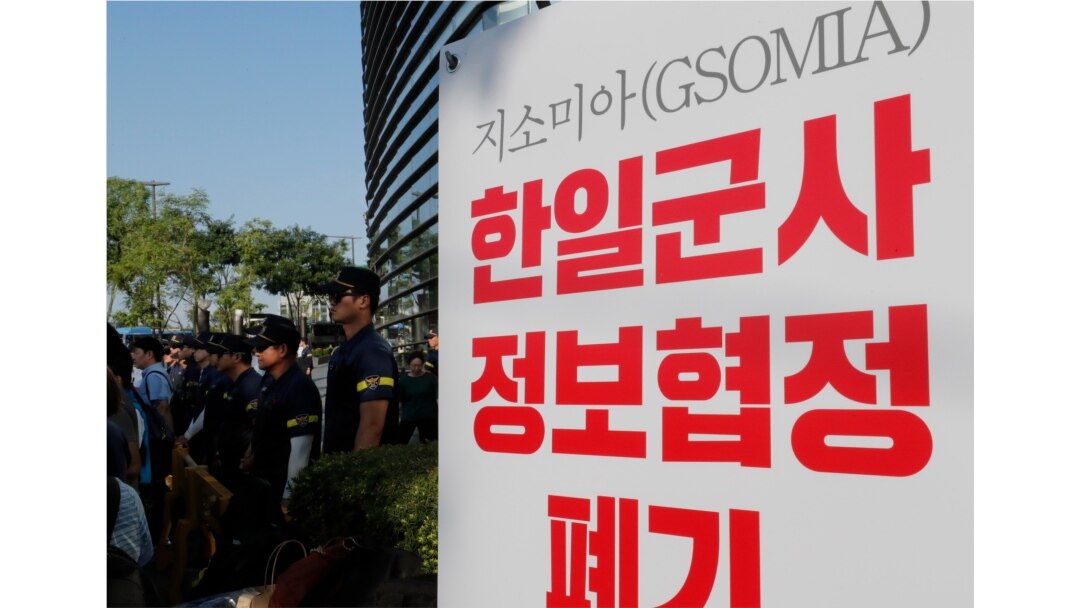 Police officers stand near a banner during a rally demanding the South Korean government cancel the General Security of Military Information Agreement (GSOMIA) with Japan, in front of the Japanese embassy in Seoul, South Korea, Aug. 22, 2019.