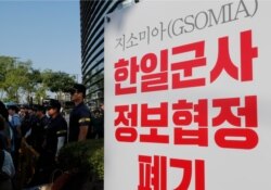 Police officers stand near a banner during a rally demanding the South Korean government cancel the General Security of Military Information Agreement (GSOMIA) with Japan, in front of the Japanese embassy in Seoul, South Korea, Aug. 22, 2019.