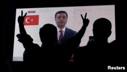 FILE - Supporters of Turkey's main pro-Kurdish Peoples' Democratic Party (HDP) watch the jailed former leader Selahattin Demirtas in a television appearance in Istanbul, Turkey, June 17, 2018.