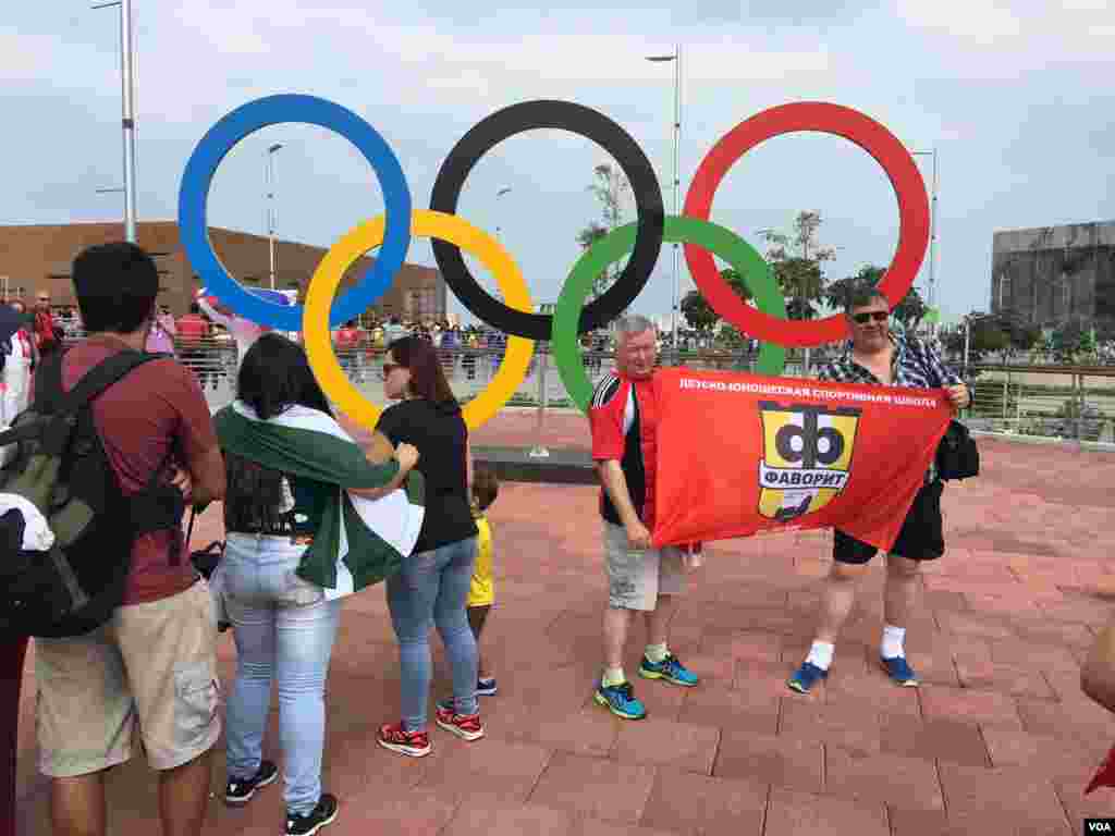 Olympic visitors get their moment with the iconic rings in Rio de Janeiro, Brazil, Aug. 8, 2016. (P. Brewer/VOA)