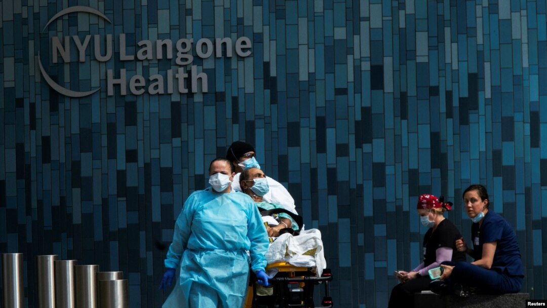 Health workers move a patient wearing a face mask at the at NYU Langone Hospital, during the outbreak of the coronavirus disease (COVID-19) in the Manhattan borough of New York City, New York, May 3, 2020.