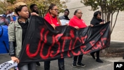 Protesters carry a sign reading “Justice for E.J.” at the Riverchase Galleria in Hoover, Ala., Nov. 24, 2018. A police officer shot and killed 21-year-old Emantic Fitzgerald Bradford, Jr. of Hueytown while responding to a shooting at the mall on Thanksgiving evening.