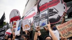 Para aktivis mengacungkan poster-poster dalam unjuk rasa anti-korupsi di luar sebuah pusat perbelanjaan di pusat kota Kuala Lumpur, Malaysia, 14 Agustus 2022. (Foto: Vincent Thian/AP Photo)