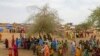 FILE - In this Thursday, July 1, 2004 file photo, Sudanese displaced women gather at the Zam Zam refugee camp just outside the town of El-Fashir in the Darfour region of Sudan, during a visit by U.N. Secretary General Kofi Annan