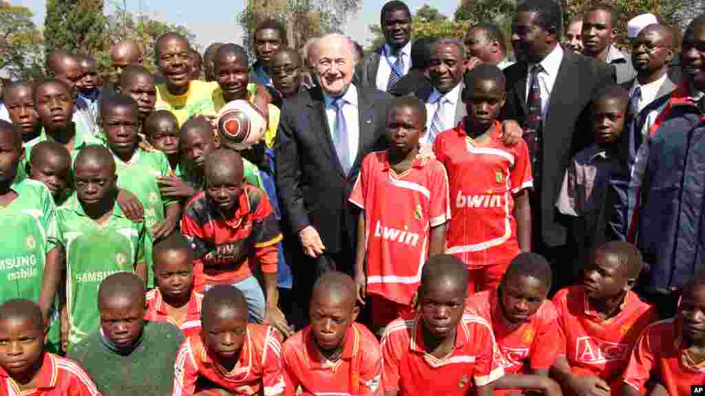 President Sepp Blatter poses for a photo with schoolchildren during his visit to the Zimbabwe Football Association Village in Mount Hampden, July 4, 2011.