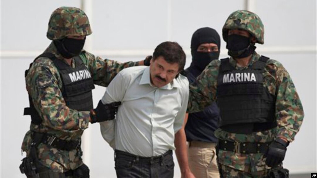 FILE - Joaquin "El Chapo" Guzman is escorted to a helicopter in handcuffs by Mexican navy marines at a navy hanger in Mexico City, Feb. 22, 2014. 