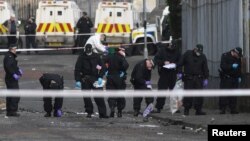 Police officers inspect the scene where the 29-year-old journalist Lyra McKee was shot dead, in Londonderry, Northern Ireland, April 19, 2019.