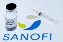 FILE - This file photo taken on Nov. 23, 2020, shows a bottle reading 'Vaccine Covid-19' next to French biopharmaceutical company Sanofi logo.