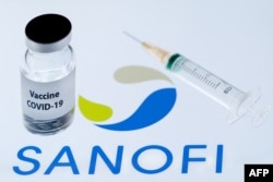 FILE - This file photo taken on Nov. 23, 2020, shows a bottle reading 'Vaccine Covid-19' next to French biopharmaceutical company Sanofi logo.