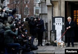 Britain's Prime Minister Boris Johnson arrives with his dog Dilyn at a polling station, at the Methodist Central Hall, to vote in the general election in London, Britain, Dec. 12, 2019.