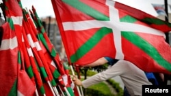 A man returns a Basque flag at the end of a rally in support of ETA prisoners in Bilbao, Spain, April 21, 2018, following an apology released by armed separatists ETA , and amid news of the group's dissolution. 