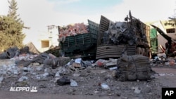 This image provided by the Syrian anti-government group Aleppo 24 news, shows damaged trucks carrying aid, in Aleppo, Syria, Sept. 20, 2016. 