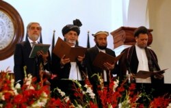 FILE - Afghan President Ashraf Ghani, second left, stands next to Afghanistan's Chief Executive Abdullah Abdullah, left, and his deputies at his inauguration in Kabul, Sept. 29, 2014.