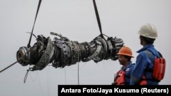 Rescue team members lift up a turbine engine of Lion Air flight JT610 at the north coats of Karawang, Indonesia, Nov. 3, 2018.