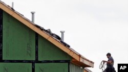 A roofer works on a home under construction in the Briar Chapel community in Chapel Hill, N.C., June 9, 2015.