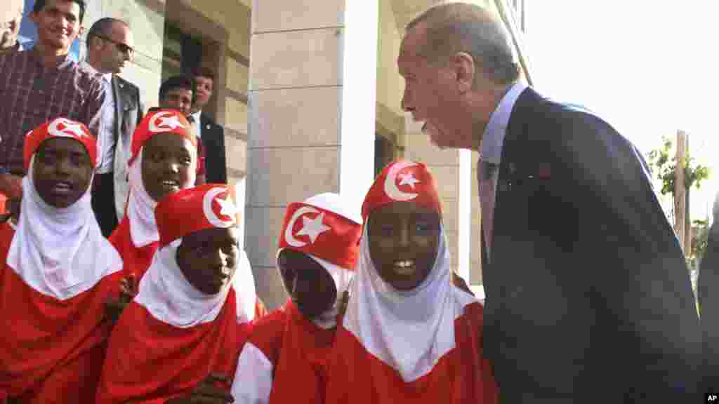 Le président Recep Tayyip Erdogan parle aux jeunes filles somaliennes qui portent des vêtements aux couleurs du drapeau turc, à Mogadiscio, 3 Juin, ici 2016.