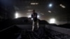 FILE - A laborer works inside a coal yard on the outskirts of Ahmedabad, India, April 6, 2017.