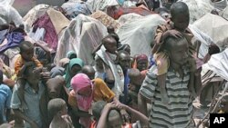 Somalis displaced by drought wait outside their makeshift shelters where tens of thousands have arrived in recent months desperately seeking food, water, shelter and other assistance, in Mogadishu, Somalia, July 25, 2011