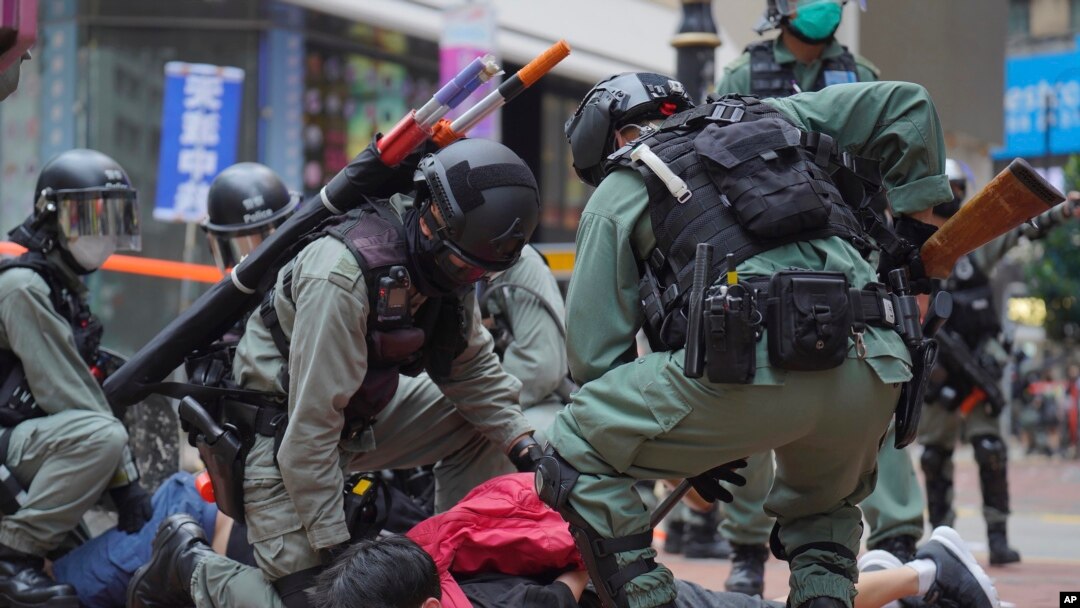 资料照：2020年5月24日，在香港铜锣湾举行的反对国安法的示威活动中，防暴警察拘留了一名抗议者。（美联社）
