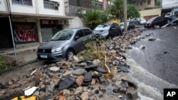 Vehicles sit on a street damaged by heavy rains in Jardim Botanico neighborhood in Rio de Janeiro, Brazil, April 9, 2019.