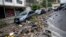 Vehicles sit on a street damaged by heavy rains in Jardim Botanico neighborhood in Rio de Janeiro, Brazil, April 9, 2019.