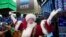 FILE - Santa Claus gestures on the floor at the closing bell of the Dow Industrial Average at the New York Stock Exchange in New York, Dec. 5, 2019.
