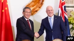 新西兰总理克里斯托弗·卢克森(Christopher Luxon)与到访的中国国务院总理李强星期四(6月13日)在双边签署一项贸易协议后握手。（法新社）