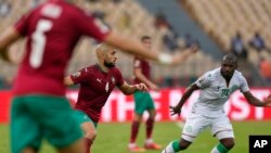 Sofyan Amrabat wa Morocco, kushoto, akimzuia El Fardou Ben Nabouhane wa Comoro, wakati wa mechi ya Kundi C ya Kombe la Mataifa ya Afrika 2022 kati ya Morocco na Comoro kwenye uwanja wa Ahmadou Ahidjo mjini Yaounde, Cameroon, Ijumaa, Januari 14, 2022. (AP. Picha/Themba Hadebe,